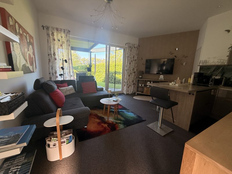 Woonkamer met open keuken en toegang tot de tuin