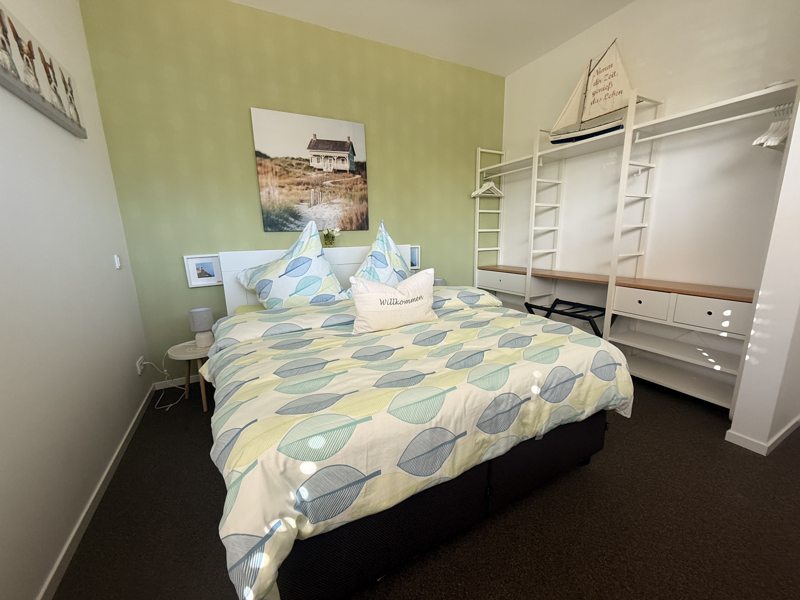 Slaapkamer met tweepersoonsbed en open kledingkast