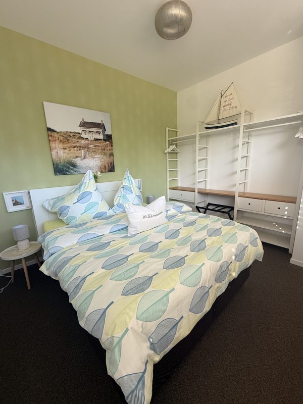 Slaapkamer met tweepersoonsbed en licht beddengoed